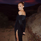 Black off-the-shoulder dress with metal ring design and high slit long sleeves.