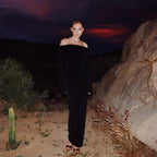 Black off-the-shoulder dress with metal ring design and high slit long sleeves.
